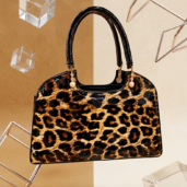 Leopard-print handbag with glossy black handles and gold hardware on display.
