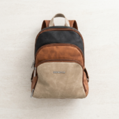 Color-block backpack with beige front pocket, brown middle panel, black top panel, and metal zippers; ERICK STYLE logo on front.