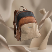 Erickstyle leather backpack with beige front, brown sides, and dark gray top; multiple zip pockets.