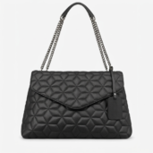 Black quilted leather handbag with chain straps and a hanging tag, shown against a light background.