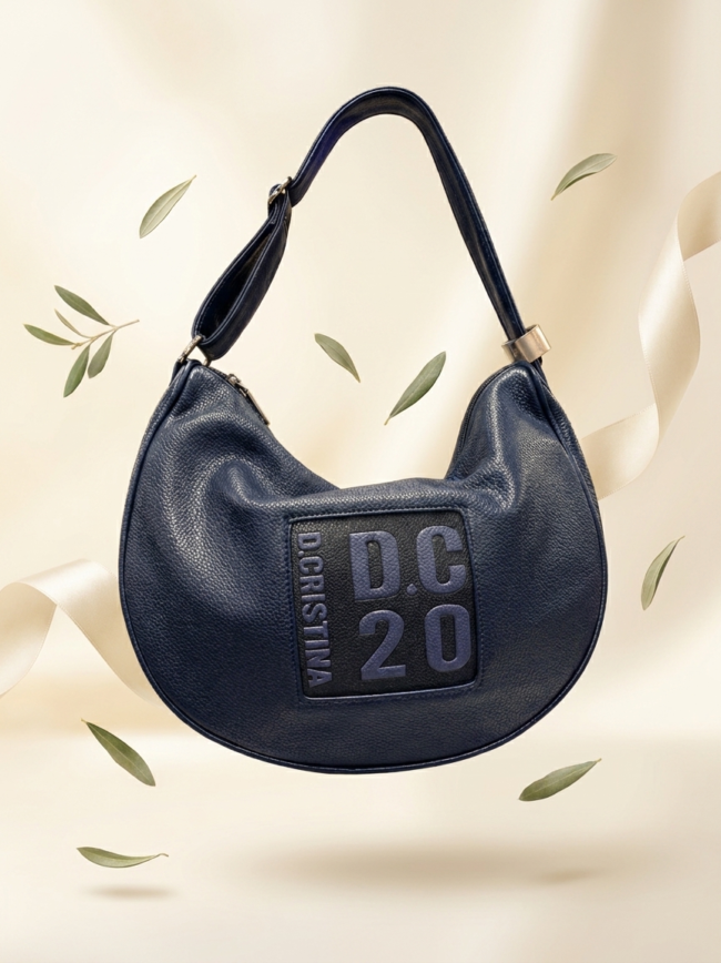 Dark blue leather hobo bag with a square patch reading 'DC20' on the front.