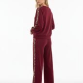 Back view of a burgundy tracksuit with leopard-print side stripe, standing against a white background. Full-length look with white sneakers.