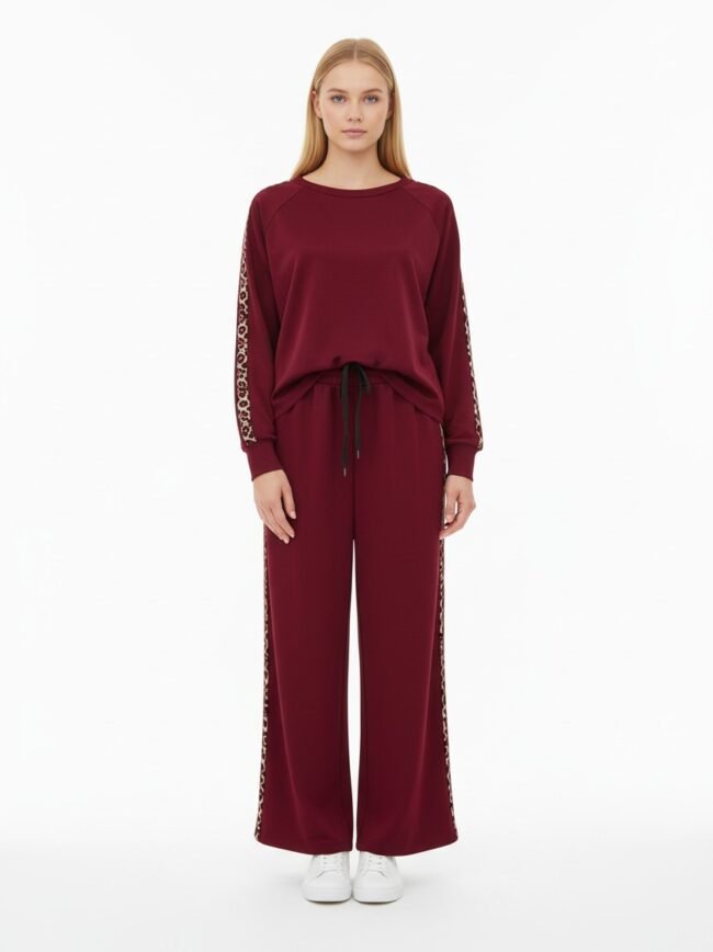 Σετ Μπορντό με Λεοπάρ 2 Model wearing a burgundy lounge set with leopard-print side stripes and white sneakers, full-body pose in a studio.