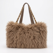 Brown fluffy handbag with gold chain straps on a light background.