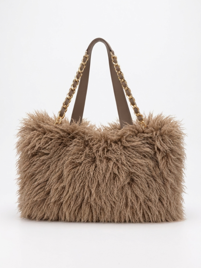 Brown fluffy handbag with gold chain straps on a light background.