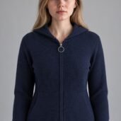 Young woman facing camera wearing a navy zip-up hoodie with a silver ring pull and ribbed hem.