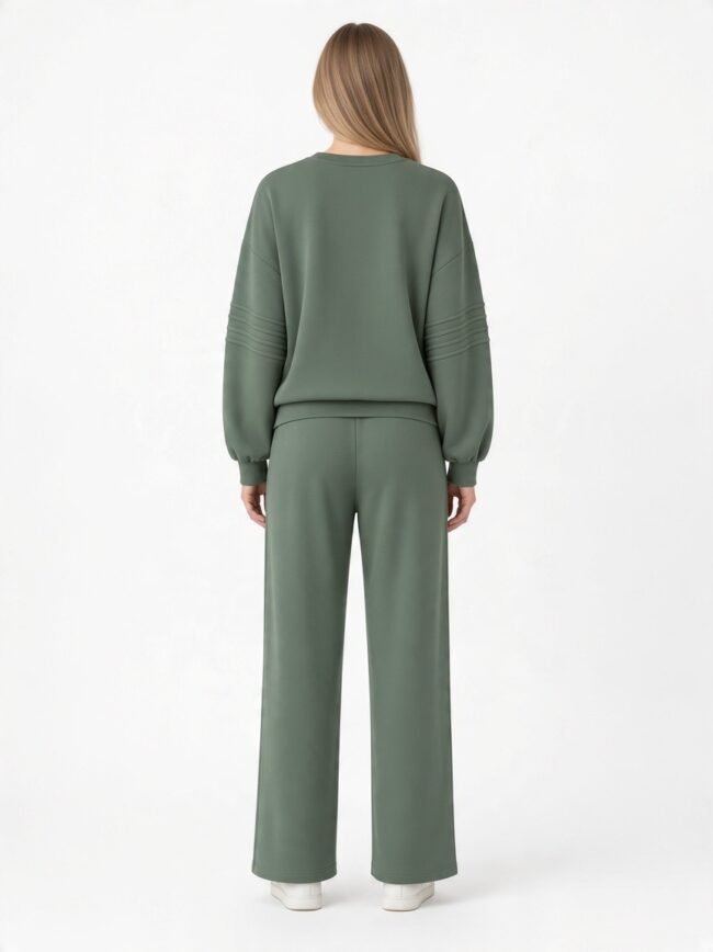 Back view of a person wearing an olive-green oversized sweatshirt and wide-leg pants set, white sneakers visible at the bottom.