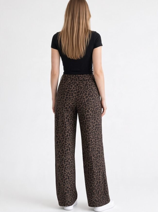 Back view of a person wearing a black short-sleeve top and brown leopard-print wide-leg pants with white sneakers.