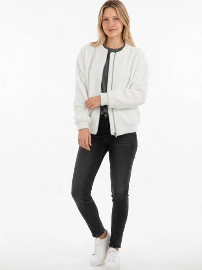 Μοντέλα μόδας AI-868d683a-1c72-41ab-aeb8-8c99366582e7 Woman in a white textured zip-front jacket over a dark top, black jeans, and white sneakers, standing against a white background.