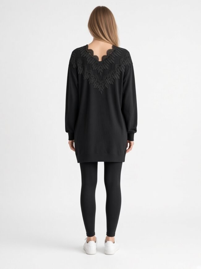 Back view of a woman wearing a black tunic with lace detailing on the upper back, paired with black leggings and white sneakers