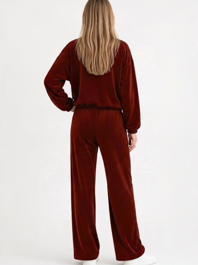 Μπορντό Σετ 2 2 Person seen from behind wearing a burgundy velour tracksuit with a loose top and wide-leg pants, white sneakers, against a light background.