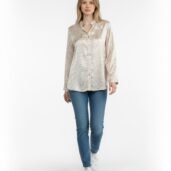 Full-body shot of a woman wearing a beige patterned button-down shirt, blue jeans, and white sneakers against a white backdrop.”] }? Wait ensure correct JSON. I included closing quote and unicode. Let's craft proper.